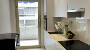 A modern kitchen with a black countertop, a sink, and a fruit bowl.