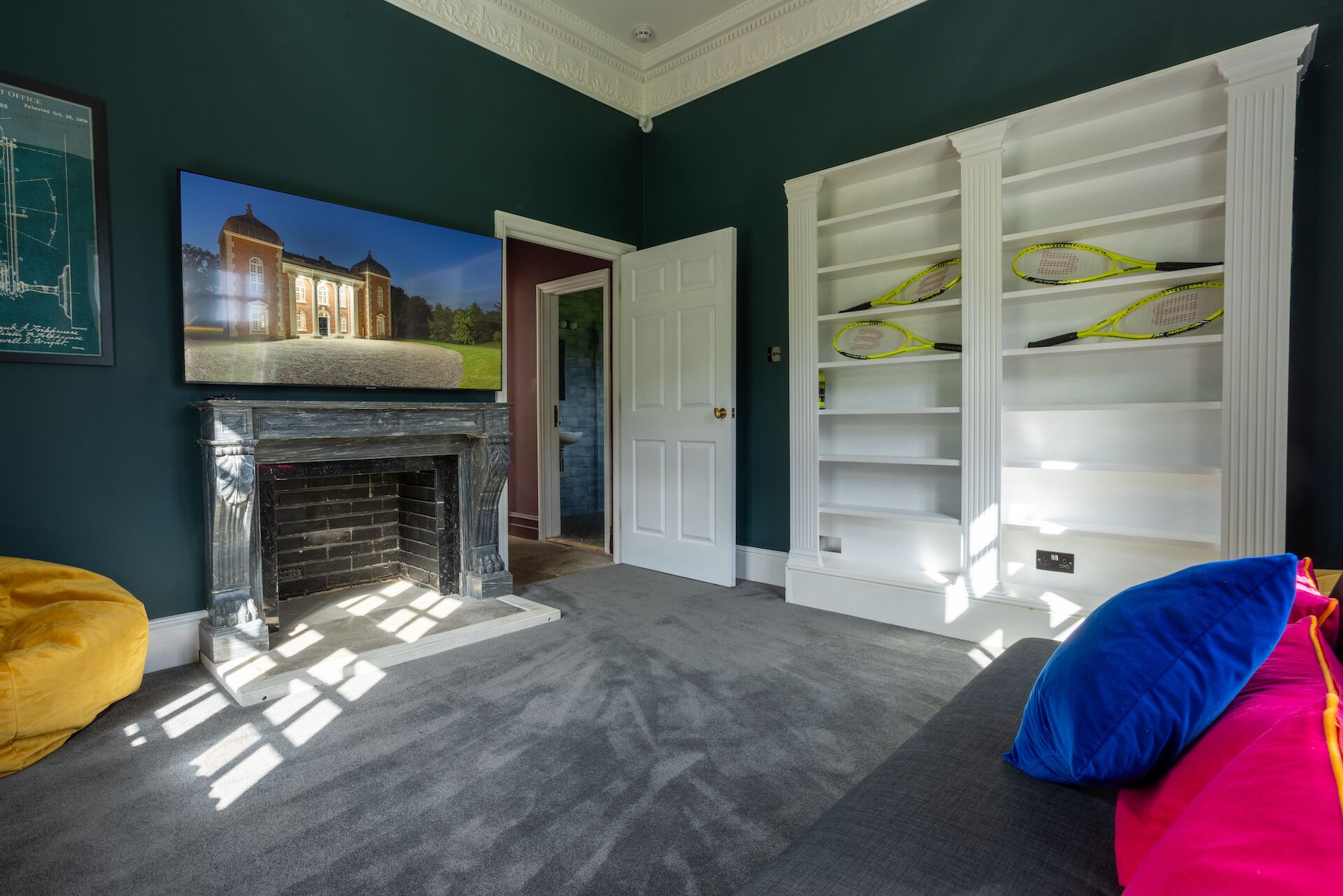 Een kamer met een open haard, een boekenkast en een bed.