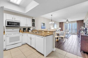 A modern kitchen with white cabinetry, a built-in microwave, and a dishwasher.