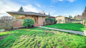 A two-story house with a brick facade, a front porch, and a well-maintained lawn. - Quaint Renton Home ~ 15 Mi to Downtown Seattle! (Renton)