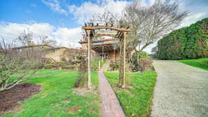 A pathway leading to a house with a wooden archway labeled "BENVENUTI". - Quaint Renton Home ~ 15 Mi to Downtown Seattle! (Renton)