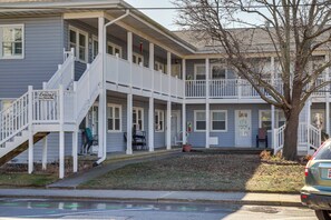 A two-story building with a covered porch and a staircase leading to the upper level. - Walk to Beach & Boardwalk! Coastal Ocean City Stay (Ocean City)