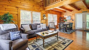 L’intérieur d’une cabine est aménagé avec du bois, il comprend un coin repas et un canapé agrémenté de coussins décoratifs.