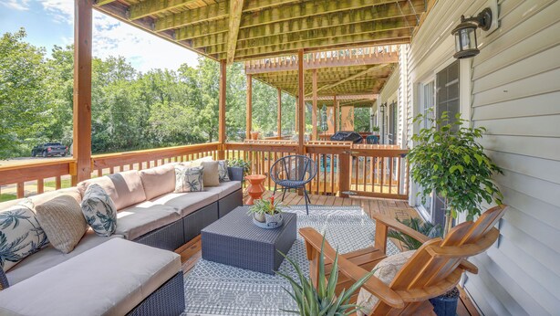 A covered outdoor deck with a sofa, chairs, and a table. - Walk to Lake Michigan - South Haven Condo! (South Haven)