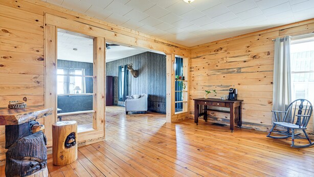A spacious room with wooden walls and floors, a rocking chair, a desk, and a chair. - Lyndon Station Retreat ~ 9 Mi to Wisconsin Dells! (Lyndon Station)
