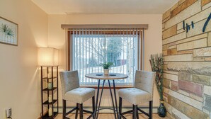 A corner room with a window, two chairs, a table, a lamp, and a decorative plant. - Montour Falls Apartment ~ 3 Mi to Seneca Lake! (Montour Falls)