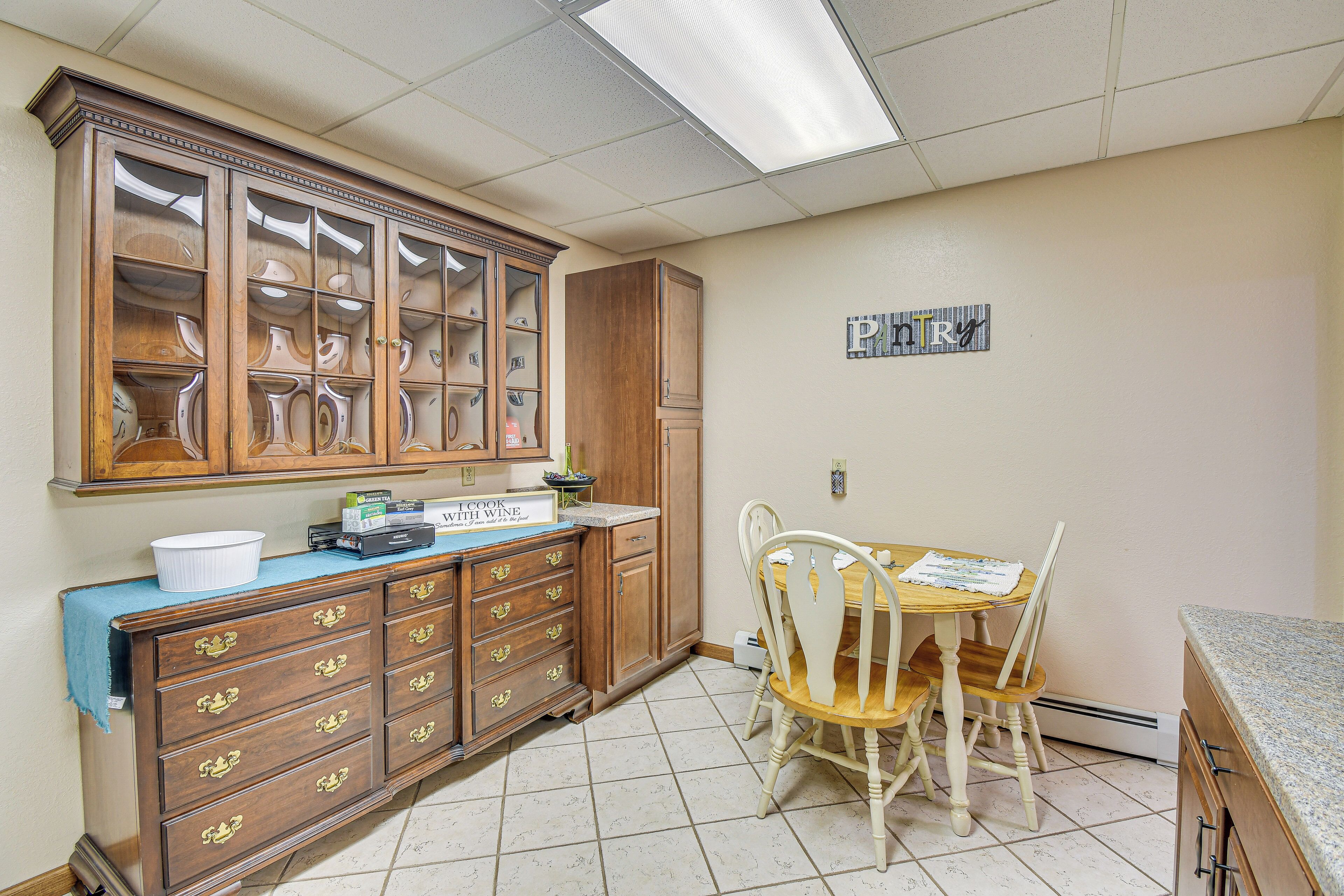 A kitchen with wooden cabinets, a dining table with chairs, and a countertop.
