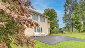 A two-story house with a covered porch, a bench, and a well-maintained lawn. - Montour Falls Apartment ~ 3 Mi to Seneca Lake! (Montour Falls)