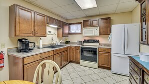 A kitchen with wooden cabinets, a microwave, a stove, and a refrigerator. - Montour Falls Apartment ~ 3 Mi to Seneca Lake! (Montour Falls)
