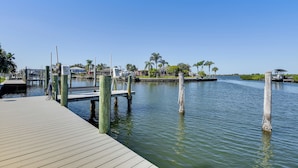 A wooden dock extending into calm water with a clear sky above. - Waterfront Palmetto Home w/ Private Pool & Dock! (Palmetto)