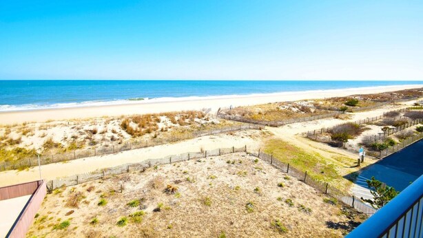 A beach view with a fenced area and a clear sky. - Beachmark 4k 1 Bedroom Condo by RedAwning (Ocean City)