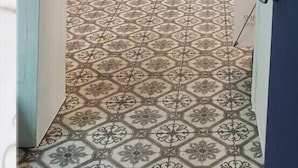A hallway with patterned floor tiles, wooden chairs, and a table. - BLAU mini hotel (Gyeongju)