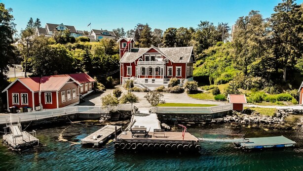 A waterfront property with a large house, dock, and clear water. - Topfloor apartment in historic villa - seaview (Vestland)