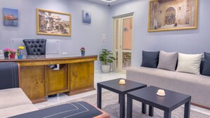 Una sala de estar moderna con un sofá de cuero, un escritorio de madera y una mesa de centro negra.