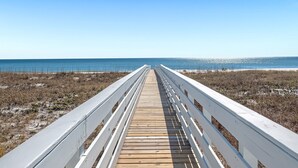 A wooden boardwalk leading to the beach with white railings. - Jolie Cote Beach House | Gulf Front | Private Pool | Beach Getaways (Pensacola)