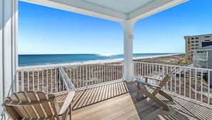 A wooden deck with a white railing overlooking a beach and ocean. - Jolie Cote Beach House | Gulf Front | Private Pool | Beach Getaways (Pensacola)