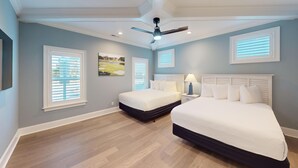 A bedroom with two beds, a ceiling fan, and a painting on the wall. - Saw Mill Sunset Beach, NC | Saw Mill 90 - 2 A (Sunset Beach)