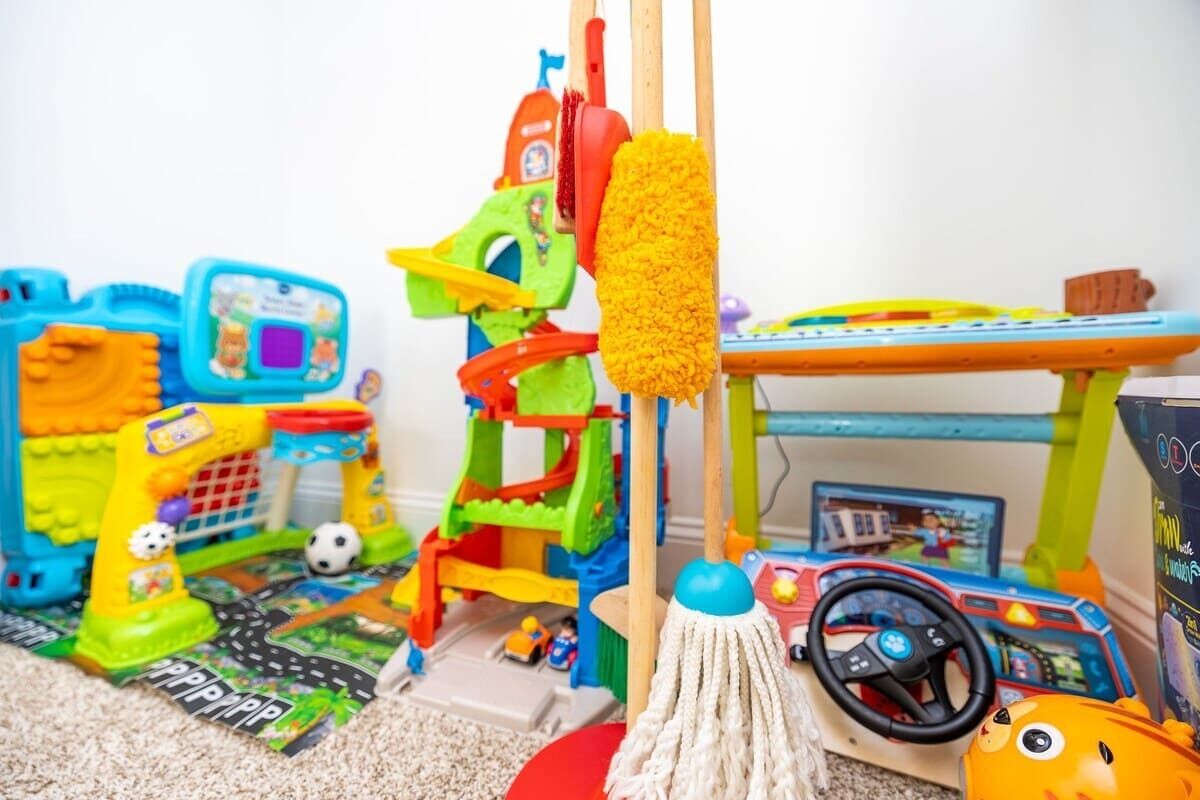 Ein Spielbereich für Kinder mit einem Spielzeugauto, einem Spielzug und einem Spielzeuggebäude.