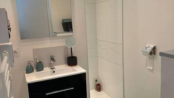 A modern bathroom with a white sink, black vanity, and a toilet.