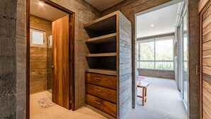 A modern interior with a wooden wardrobe, a built-in shelf unit, and a view through a large window. - Modern Condo In Walking Distance to Surf Beach (Bahias de Huatulco)