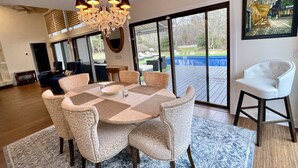Un espace repas agrémenté d’un lustre, d’une grande table et de chaises.