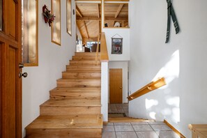 A wooden staircase leading to a second floor with a wooden door at the top.