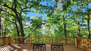 A wooden deck with two chairs and a table, surrounded by trees and a clear sky. - Eureka Springs getaway 2 acres in the center of town, super close to historic DT (Eureka Springs)