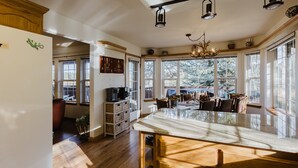 Une cuisine spacieuse, dotée de grandes fenêtres, d’un plancher en bois et d’un îlot central.