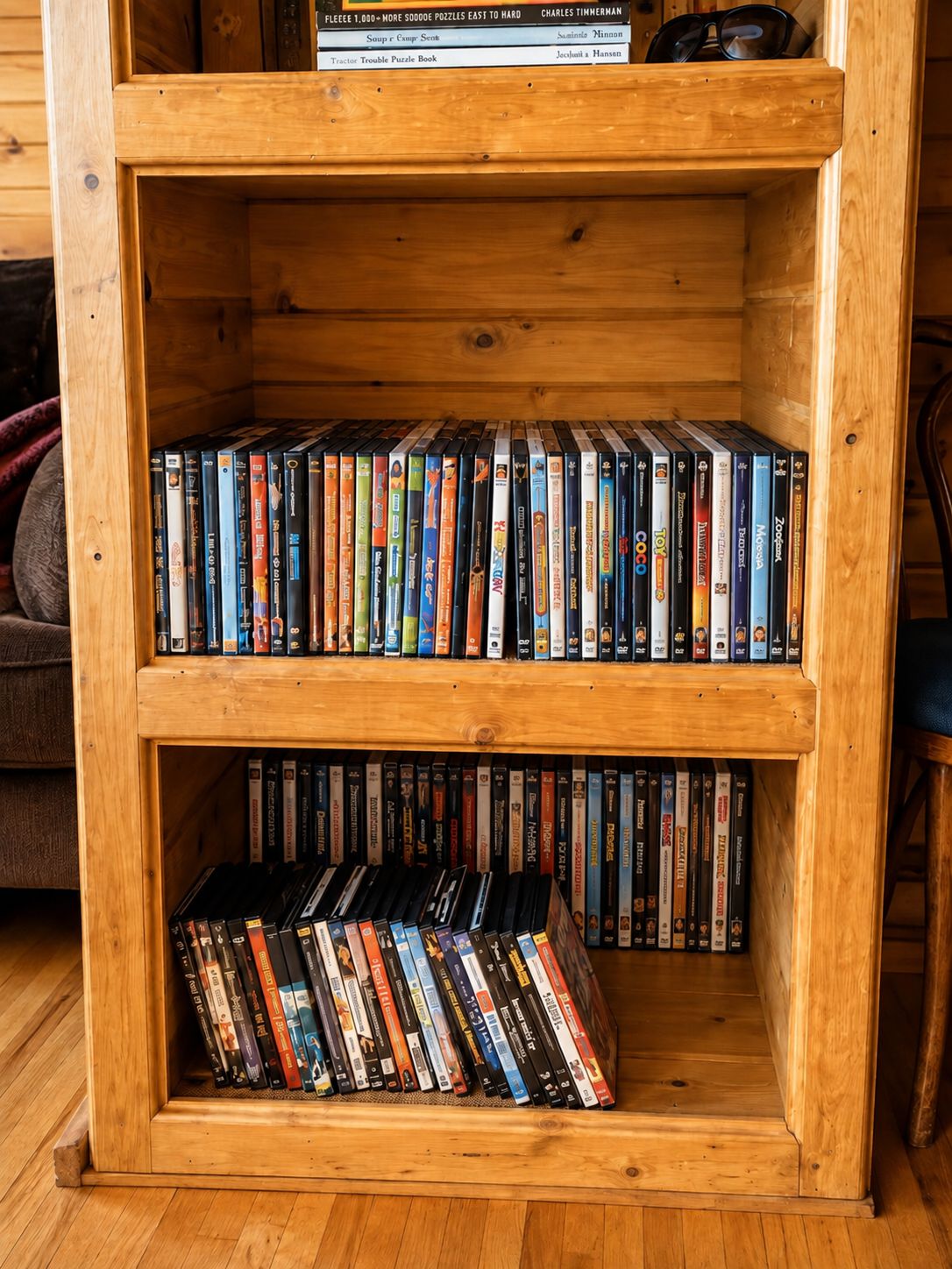 Una estantería de madera con varias repisas llenas de DVDs.