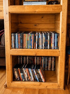 A wooden bookshelf with multiple shelves filled with DVDs. - 30% OFF Members. Riverfront. Lake Of the Woods 2mi. Pets Free (Warroad)