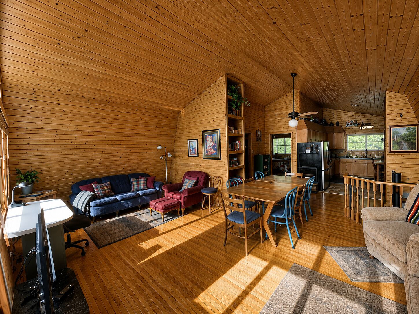 Ein gemütliches Blockhaus-Interieur mit Essbereich, Küche und Wohnzimmer, möbliert mit Holzmöbeln.