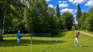 An outdoor netted area with a clear sky and trees in the background.