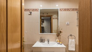 Een moderne badkamer met een wastafel, spiegel en handdoekhouder.