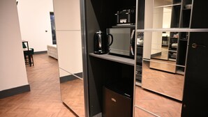 A modern kitchen with a coffee maker, microwave, and a small refrigerator.