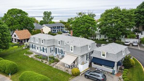 A two-story house with a garage, a lawn, and a view of the water. - The Ogunquit Getaway - 177 Shore Road (Ogunquit)