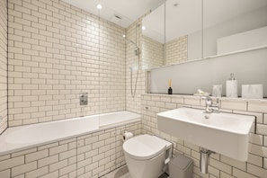 Ein Badezimmer mit einer weißen Badewanne, einem Waschbecken und einer Toilette.