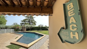 A pool area with a sign indicating 'BEACH THIS WAY'.