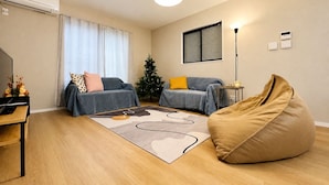 Ein modernes Wohnzimmer mit einer Couch, einem Sitzsack, einem Couchtisch und einem Weihnachtsbaum.