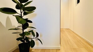 Ein Flur mit Blumentopf, kleinem Bilderrahmen und Holzboden.