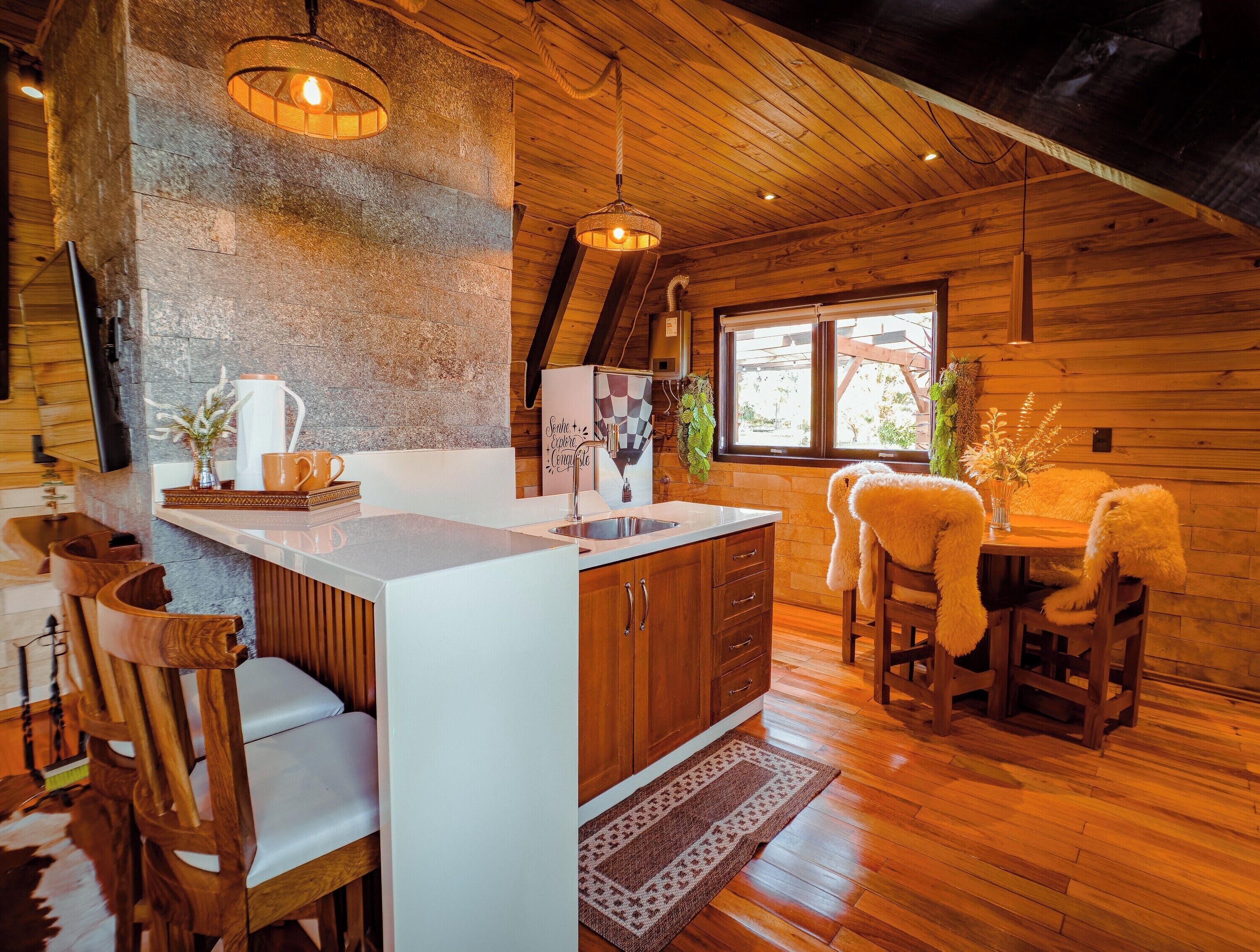 Una cocina acogedora con una isla de madera, una zona de comedor con mesa y sillas, y un ventanal con vistas.