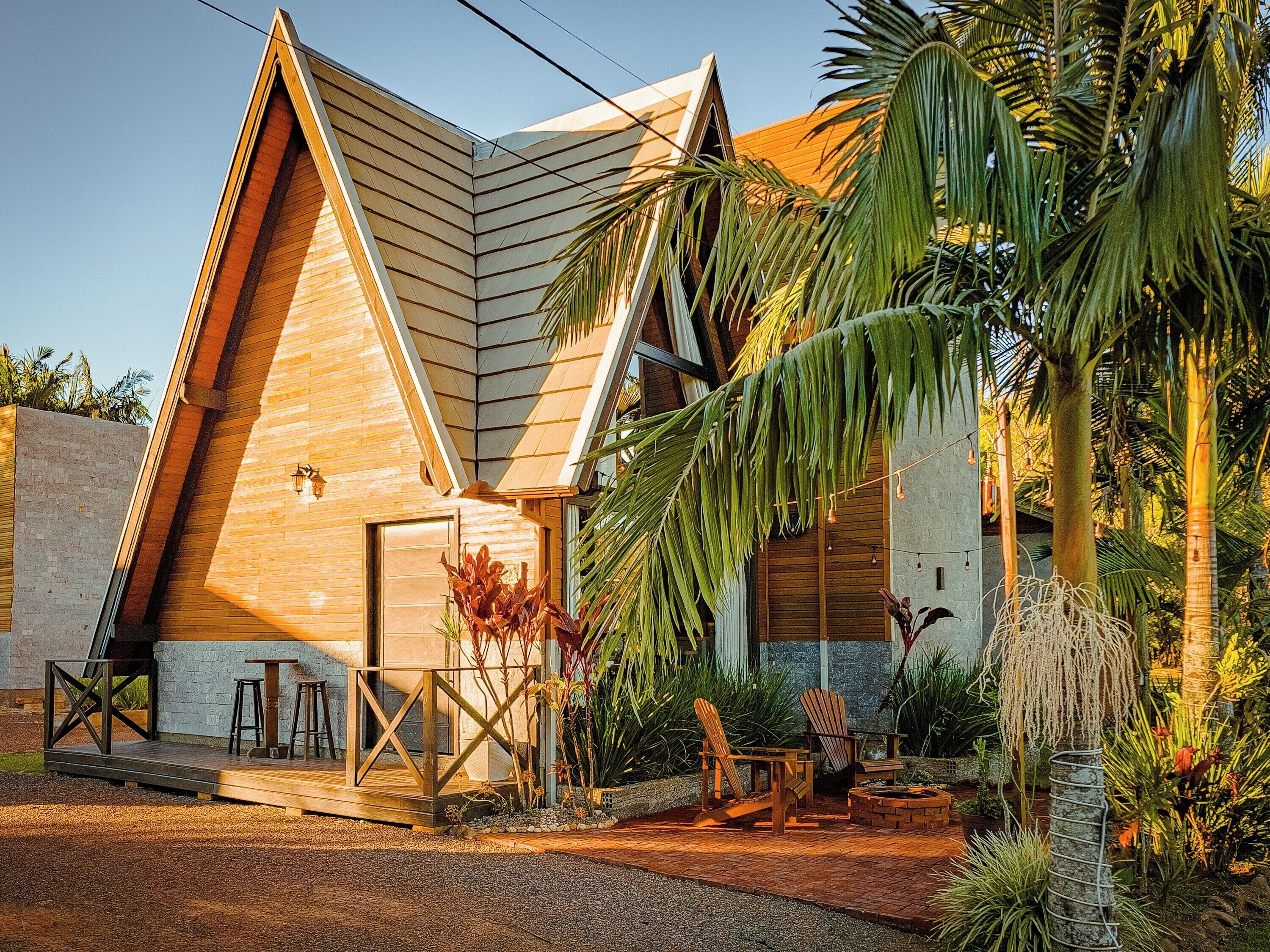 A modern house with a sloped roof, a wooden deck, and outdoor seating.