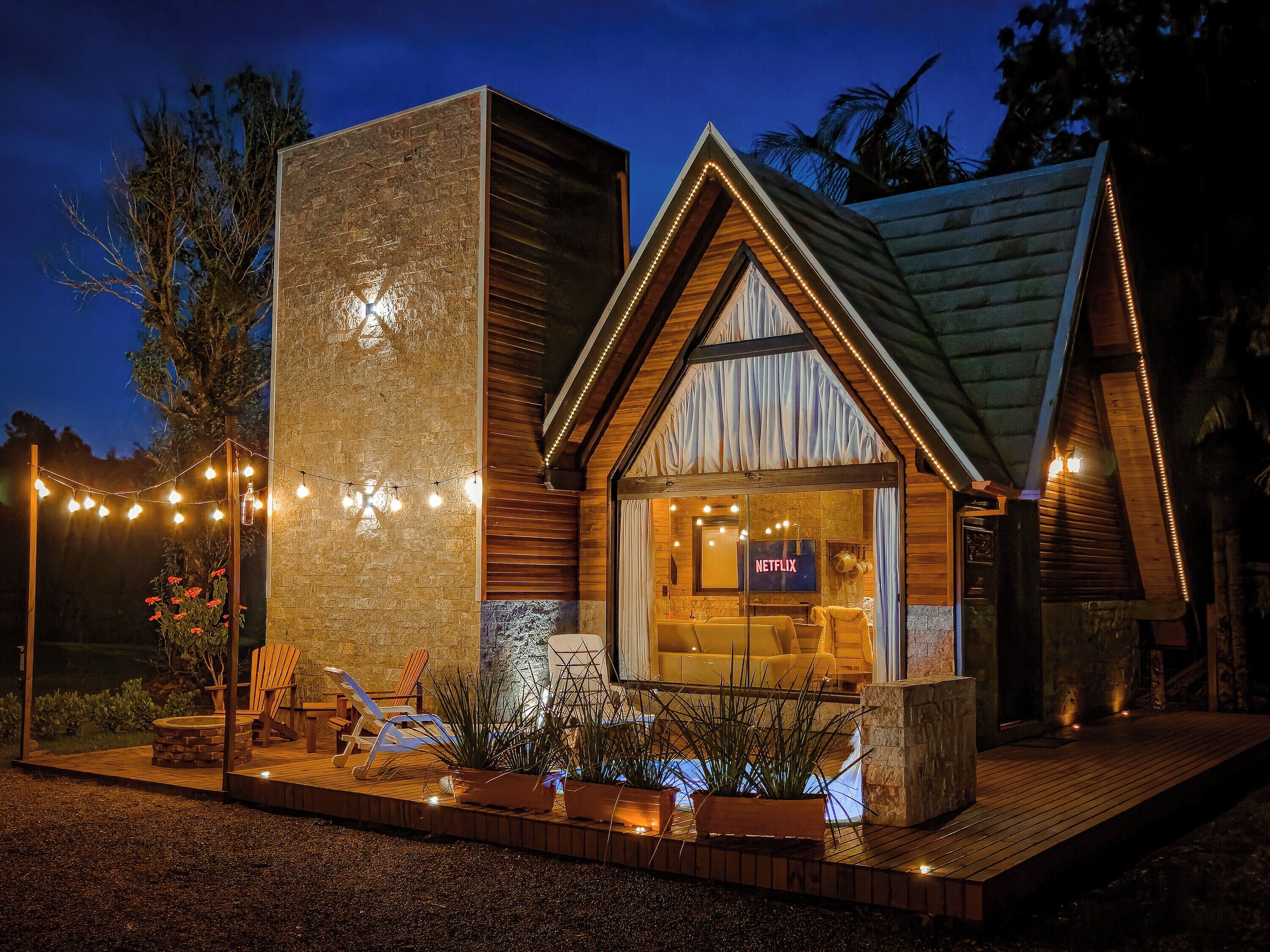 Una casa moderna con fachada de piedra, interior de madera y un letrero de Netflix.