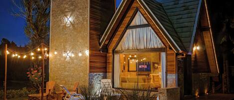 Una casa moderna con fachada de piedra, interior de madera y un letrero de Netflix.