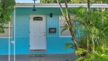 A house with a blue exterior, a white door, and a small porch area.