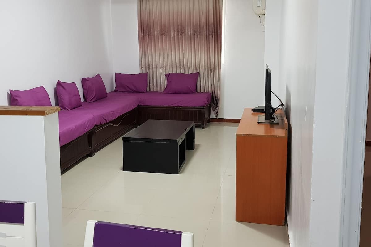 A living room with a sectional sofa, a coffee table, and a TV stand.