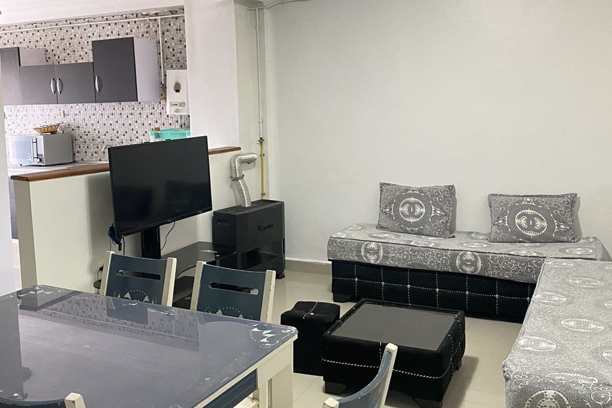 A compact living space with a dining area, a kitchenette, and a sofa set.