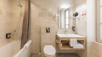 A modern bathroom with a bathtub, toilet, and sink.