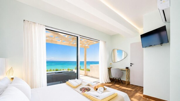 Ein Hotelzimmer mit Bett, Schreibtisch, Fernseher und Meerblick.