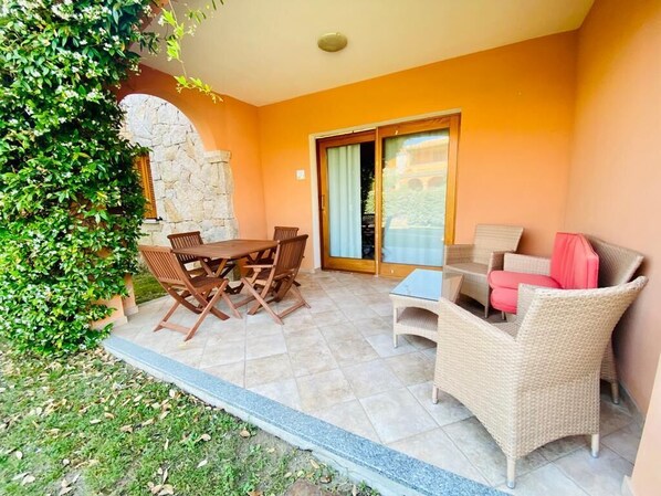 A patio area with a dining table and chairs, a sofa, and a small table. - Residence Lu Mulinu con Piscina  (San Teodoro)