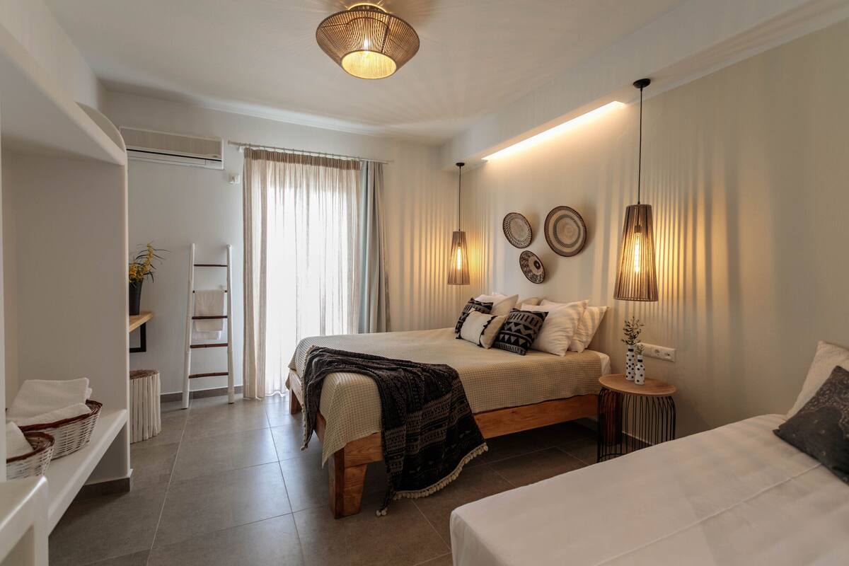 A modern bedroom with a large bed, bedside tables, a wardrobe, and a bathroom with a towel rack.